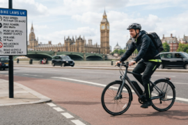 cyclist riding past sign displaying UK ebike laws